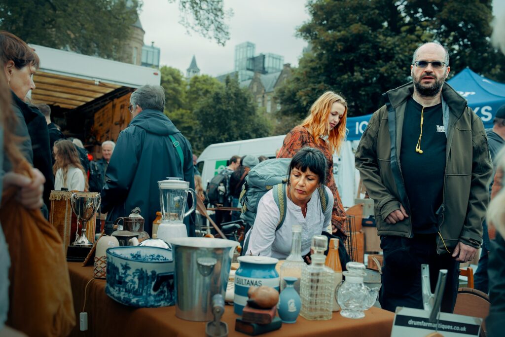 Stalls at an outdoor market in Edinburgh with shoppers browsing