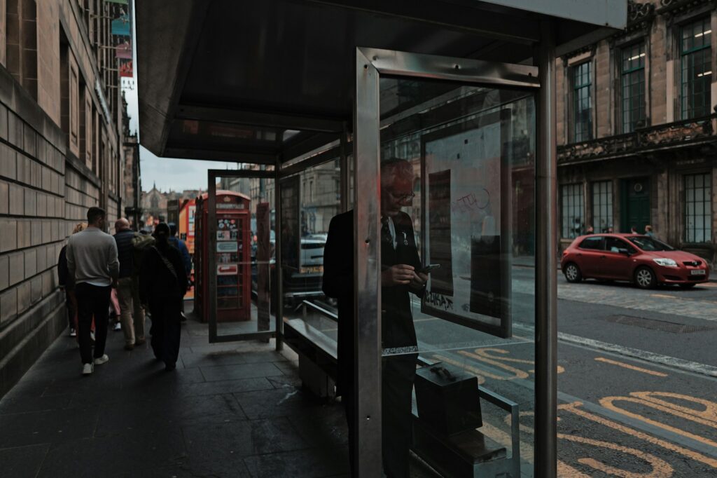 People waiting at a bus stop on an Edinburgh street