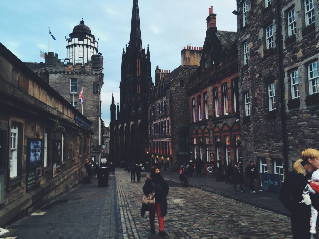 Pedestrians walking the Royal Mile in Edinburgh on a wet grey day