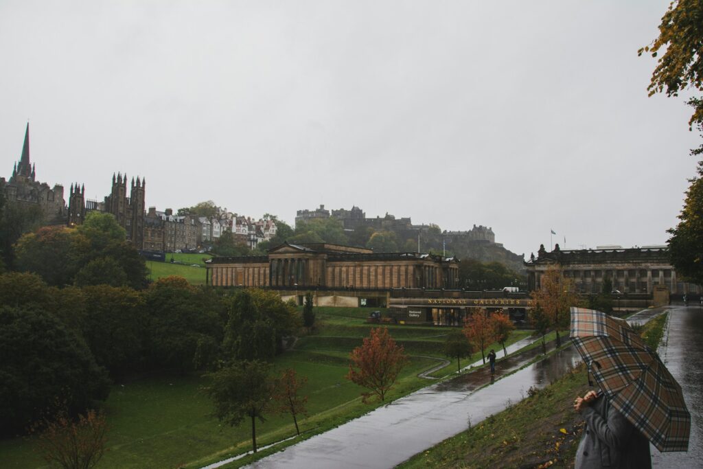 Rue d'Édimbourg sous la pluie avec le château visible à travers le crachin
