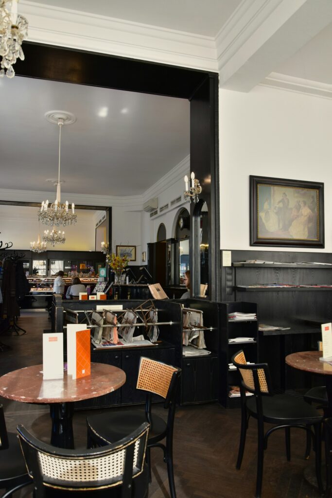 Viennese coffee house interior with marble tables, bentwood chairs and a newspaper rack