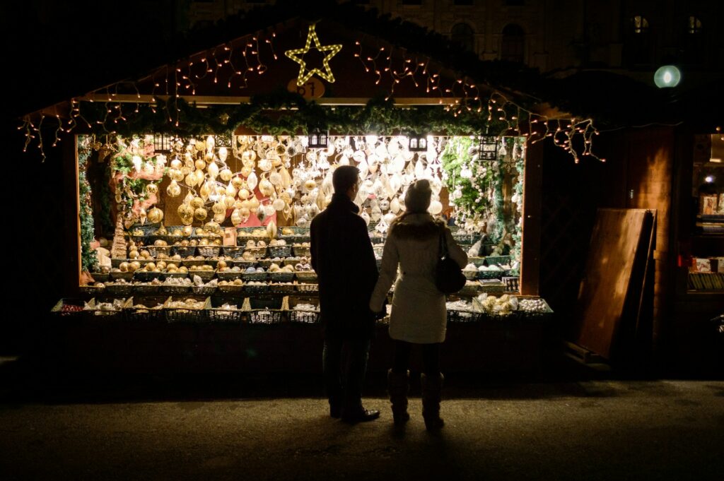 A couple at a lit Christmas market stall in Vienna at night