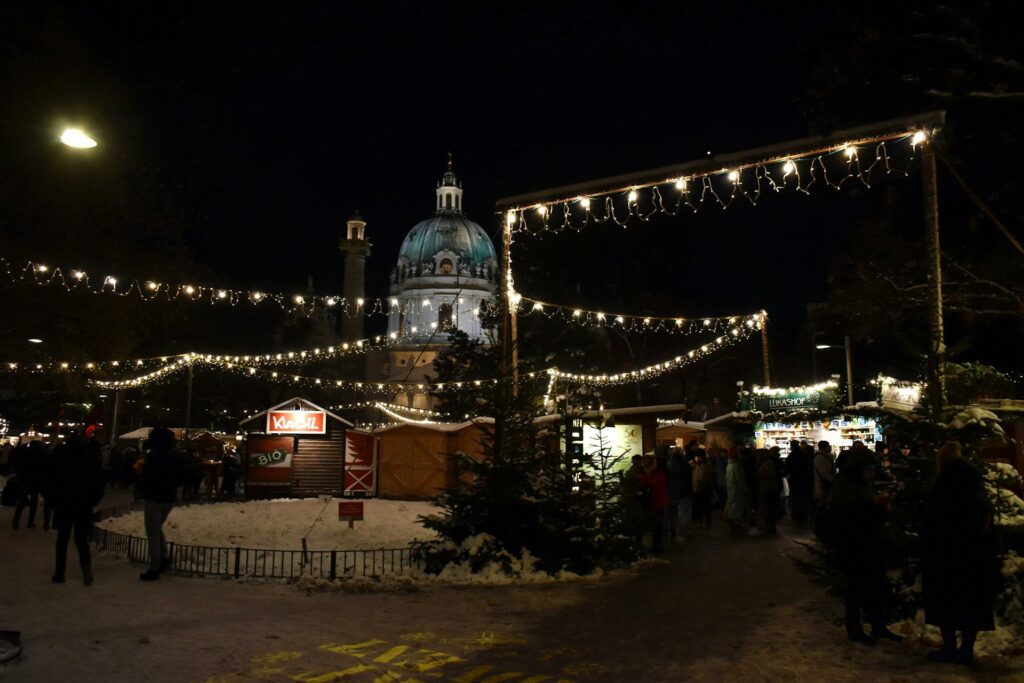 Der Christkindlmarkt am Karlsplatz in Wien mit der Kuppel der Karlskirche im Hintergrund