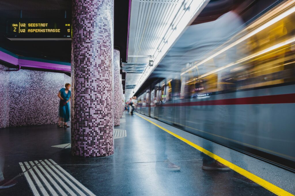 Metro platform in Vienna with a train passing