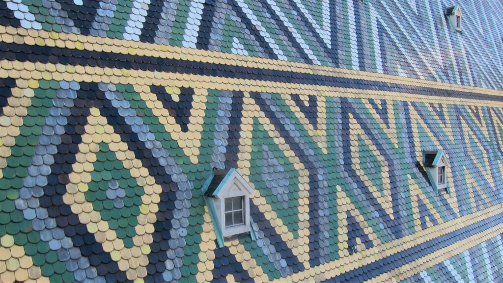 Gros plan sur les tuiles vernissées à motifs du toit de la cathédrale Saint-Étienne à Vienne
