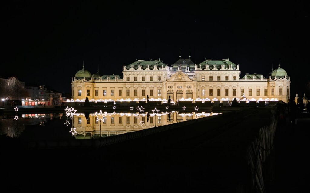 Le Belvédère supérieur à Vienne illuminé la nuit et reflété dans le bassin