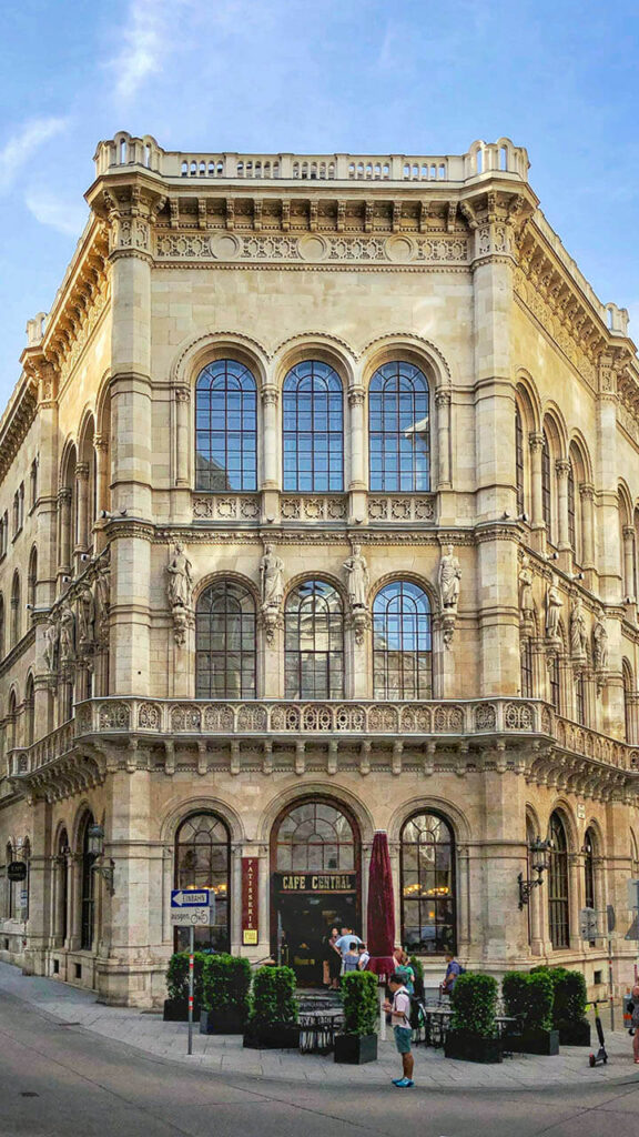 Interior of a historic Viennese coffee house with vaulted ceilings and marble tables