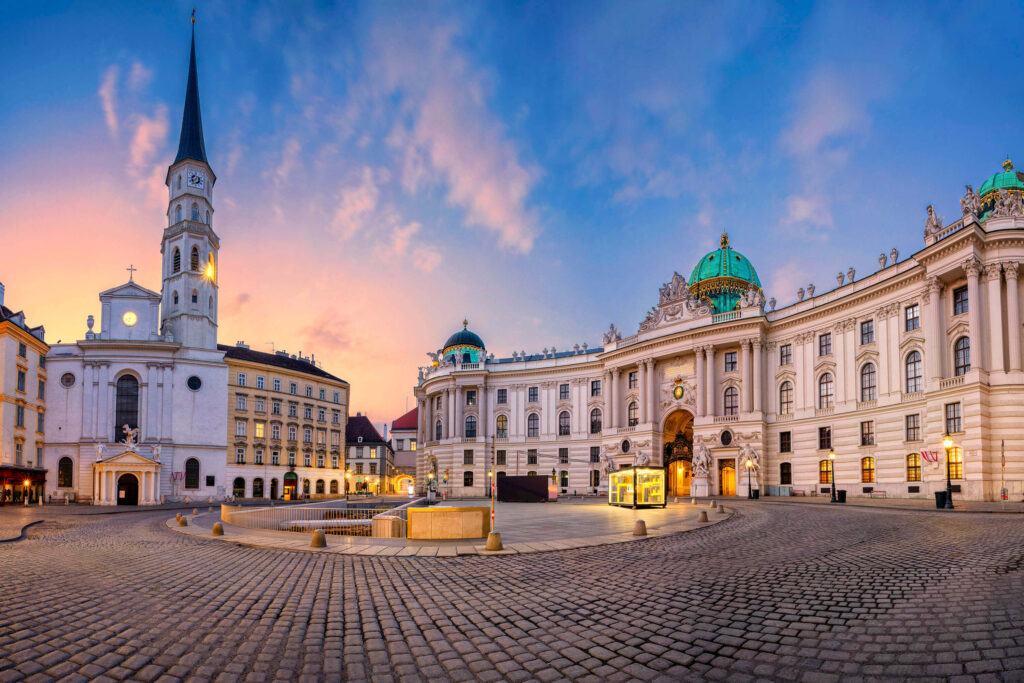 Michaelerplatz y la puerta con cúpula de la Hofburg de Viena al atardecer