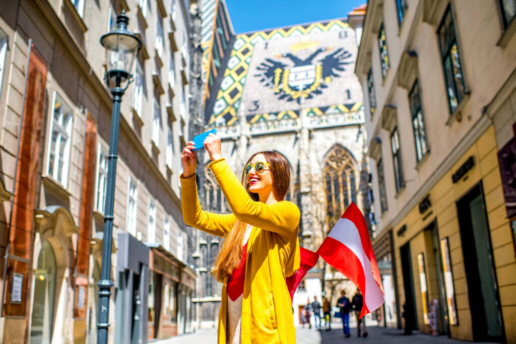 Viajera caminando por el centro de Viena con el móvil en la mano